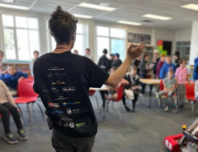 A teammate presenting our robot to local middle-school students.